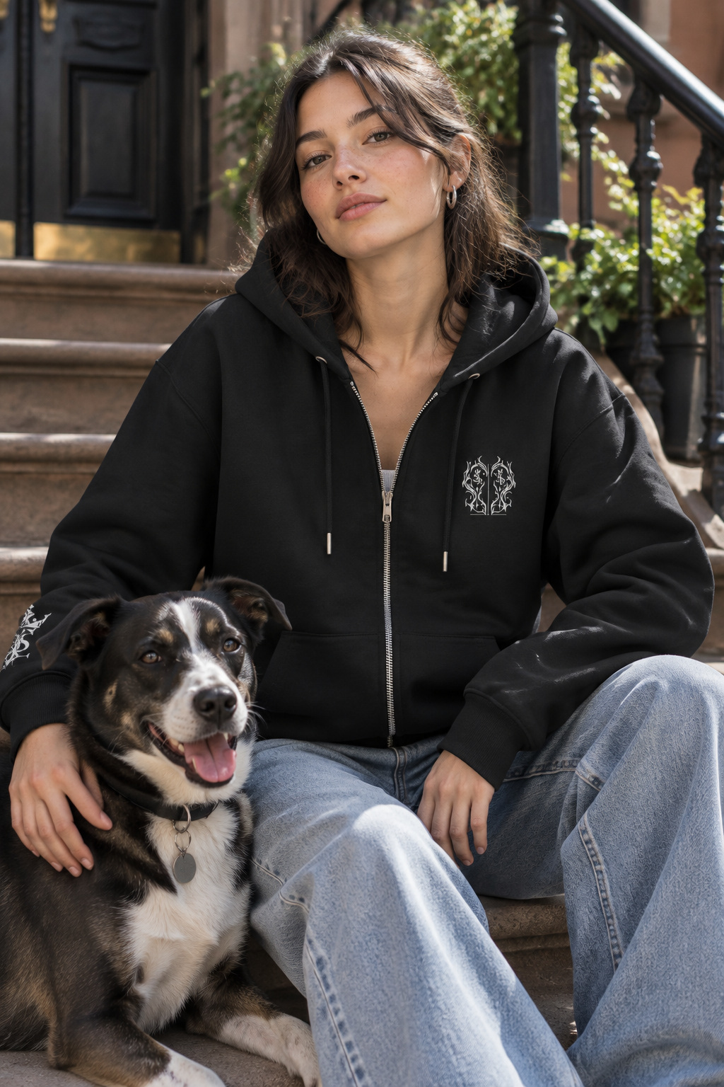 Woman wearing the Santos Legacy Signature Premium Unisex heavyweight zip-up hoodie on a brownstone stoop with her dog