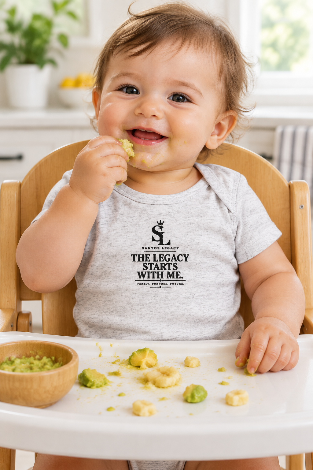 Baby wearing the Santos Legacy Little Legacy Baby jersey bodysuit playing with soft food in a wooden high chair