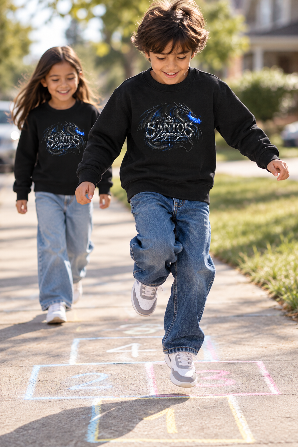 Two kids wearing the Santos Legacy Signature Premium Kids crew neck sweatshirt playing hopscotch on a sunny sidewalk