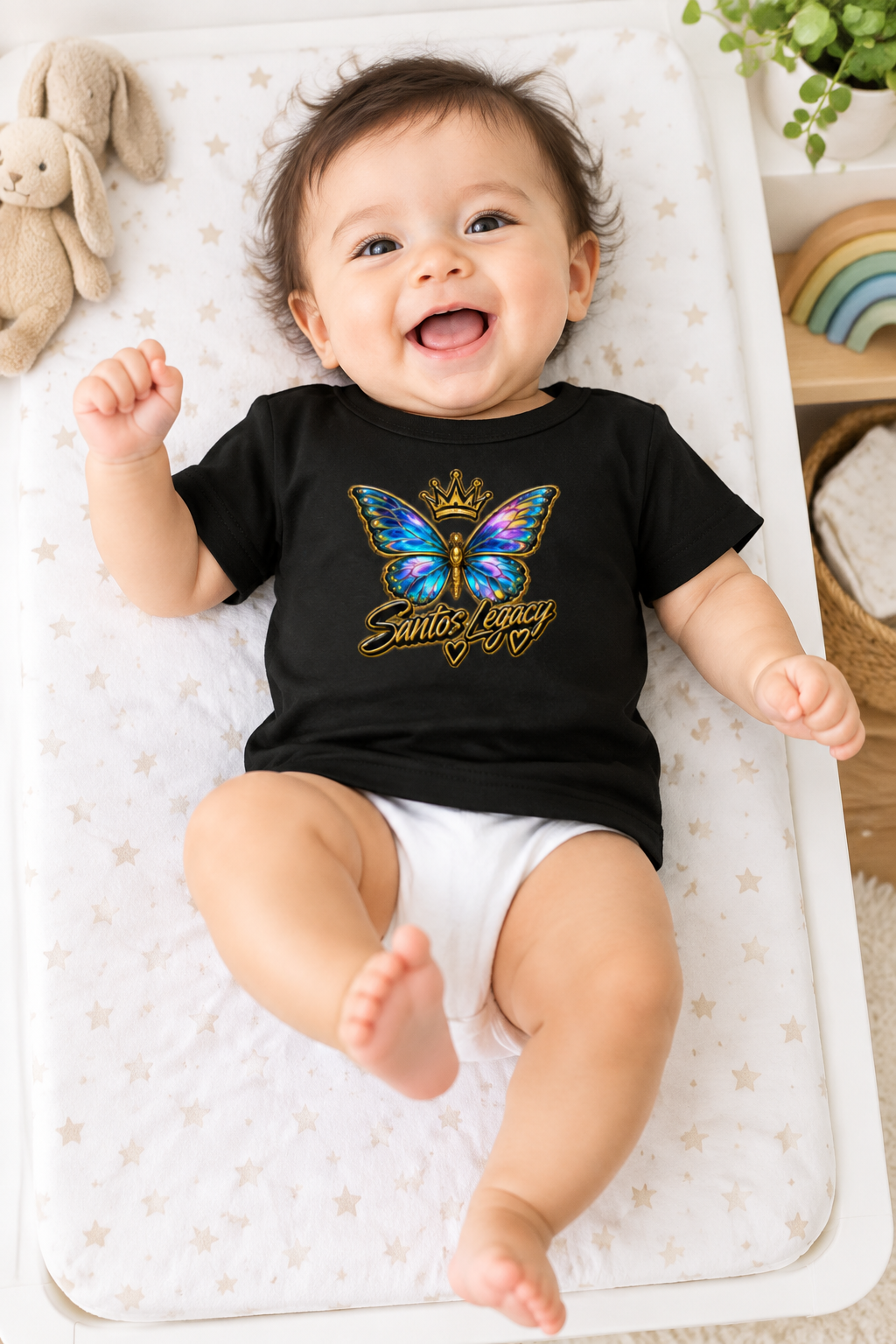 Baby wearing the Santos Legacy Baby Jersey Short Sleeve Tee kicking happily on a changing mat
