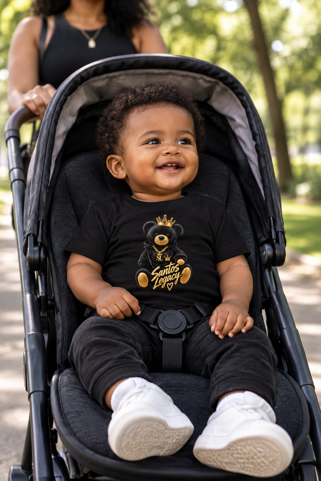 Baby wearing the Santos Legacy Baby Jersey Short Sleeve Tee in a stroller on a park path